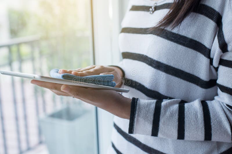 Hand Woman Cleaning Tablet on Screen with Microfiber Cloth Stock Photo