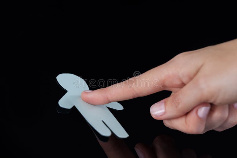 Hand of a woman touching human paper cut out on a glass royalty free stock images Hand of a woman touching human paper cut out on a glass royalty free stock images