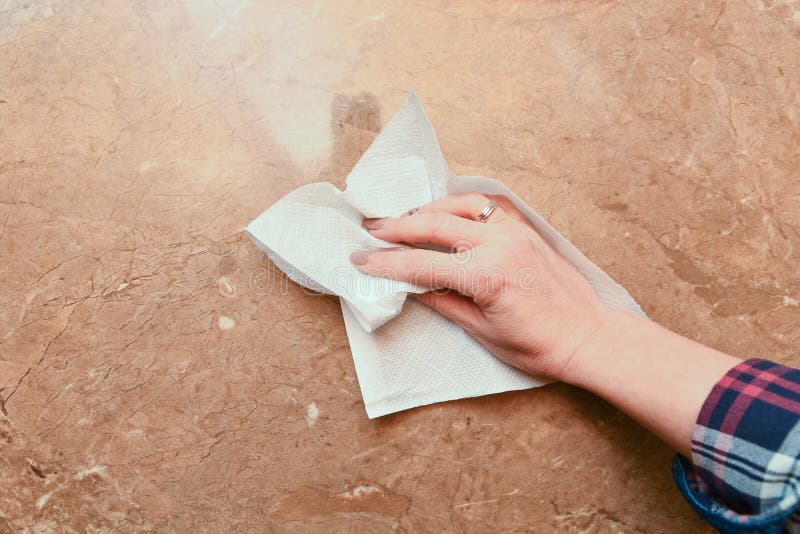 Hand of woman wiping the table with a towel