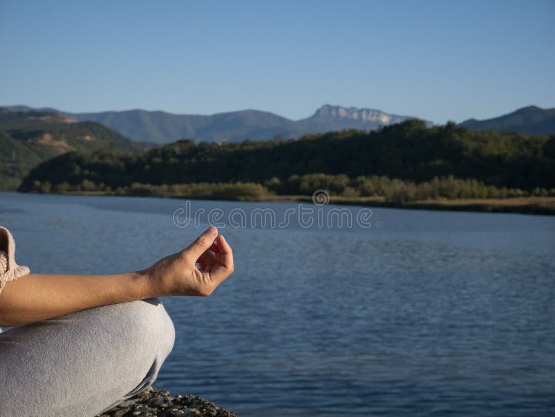 Hand woman yoga and lotus pose meditation and relax in the mountan lake. Healthy and Zen Concept Close up royalty free stock image Hand woman yoga and lotus pose meditation and relax in the mountan lake. Healthy and Zen Concept Close up royalty free stock image