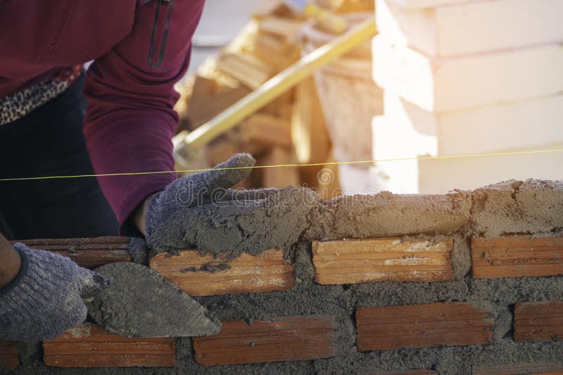 Hand of Worker Installing Bricks on Construction Site Stock Image