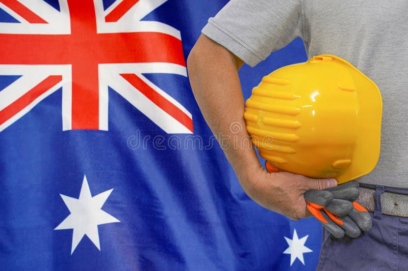 Hand of Worker and Yellow Hardhat on Background Flag of Australia