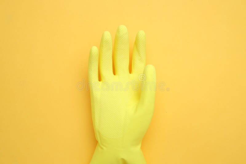 Hand in yellow glove isolated on yellow background,top view,Copy space for the ads