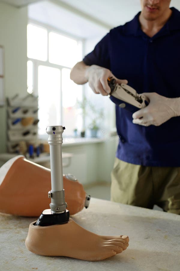Handarbeiter vor Tisch mit Beinprothese stockfotos