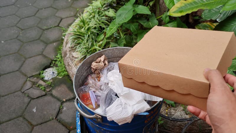 Handbewegung junger Menschen, die Müll in die Müllhalde werfen