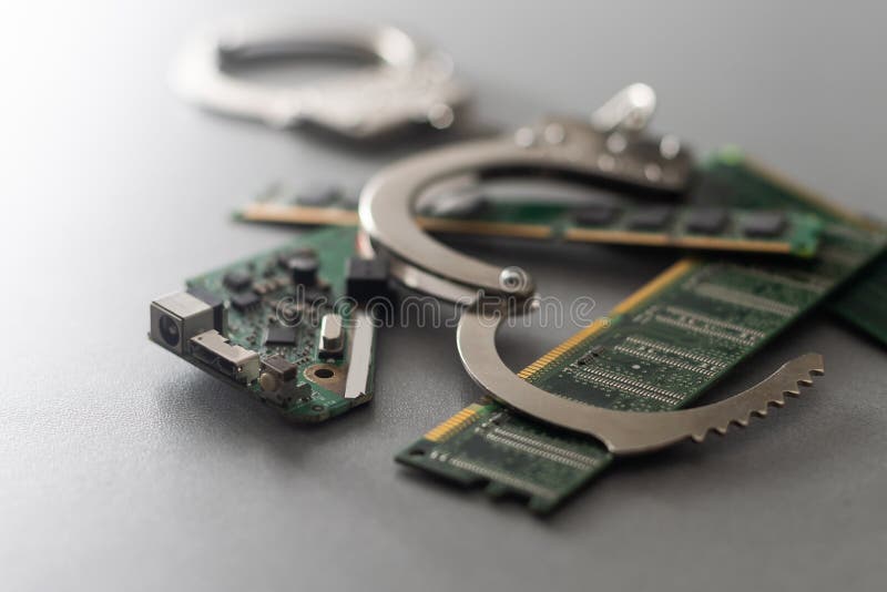 Handcuffs Against a Computer Electronics Board. the Concept of