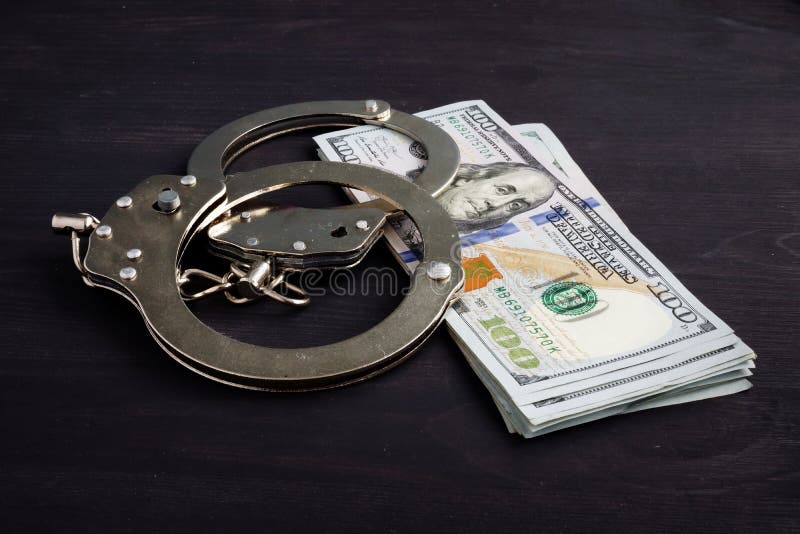 Handcuffs and money. Dollars for bail bonds royalty free stock photography Handcuffs and money. Dollars for bail bonds royalty free stock photography