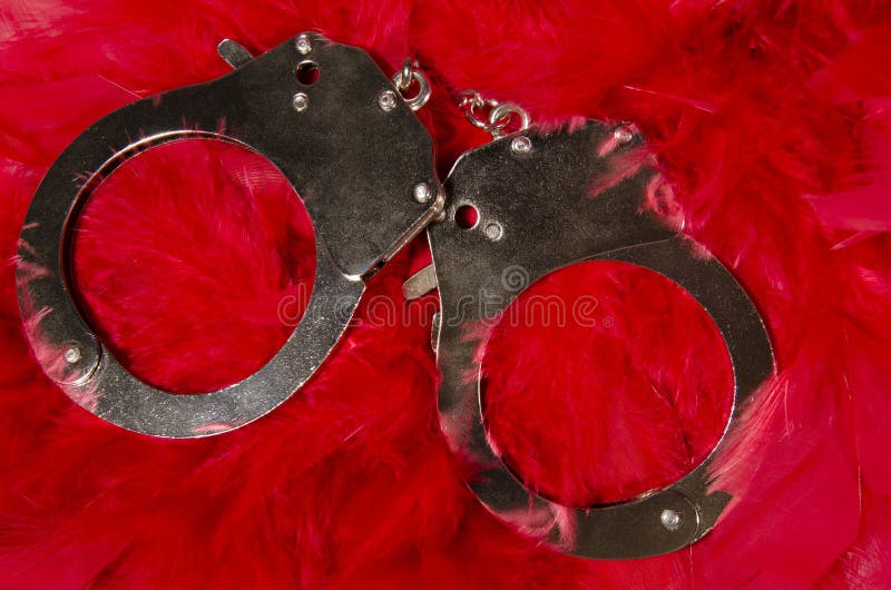 Handcuffs on red feathers stock image. Image of love 27811997