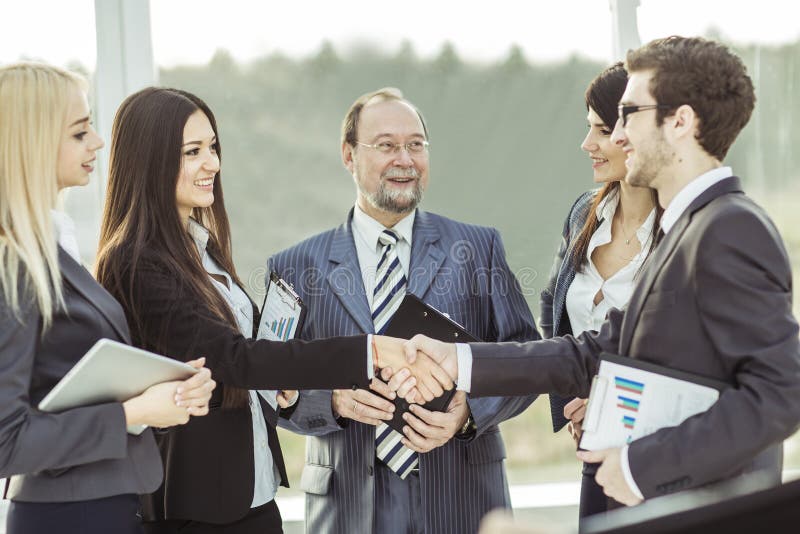 Closeup of handshake financial partners, and attorneys of the company on the background of the office. Closeup of handshake financial partners, and attorneys of the company on the background of the office