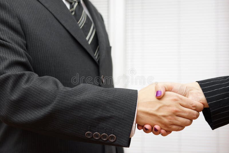 Handdruk van partners, de mens en vrouw in het bureau stock afbeeldingen Handdruk van partners, de mens en vrouw in het bureau stock afbeeldingen
