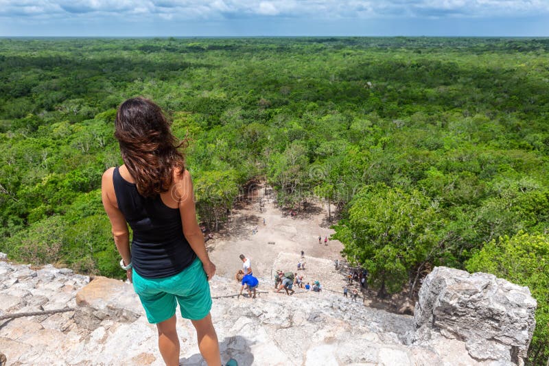 Handelsresandekvinnan ser den Nohoch Mul pyramiden i Coba, Yucatan, Mexico royaltyfria foton Handelsresandekvinnan ser den Nohoch Mul pyramiden i Coba, Yucatan, Mexico royaltyfria foton