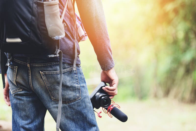 Handelsresandemannen som rymmer kameran på naturskogturist på feriesemesterturer, äventyrar ryggsäckar för loppvandringfolk arkivbild Handelsresandemannen som rymmer kameran på naturskogturist på feriesemesterturer, äventyrar ryggsäckar för loppvandringfolk arkivbild