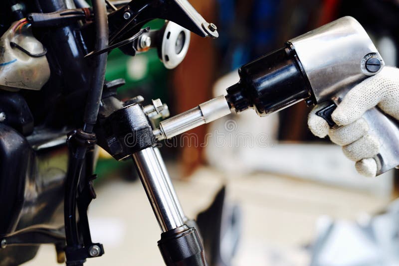 Handen av mekanikermannen byter ut och justerar systemet för den bakre bromsen för motorcykeln arkivbilder Handen av mekanikermannen byter ut och justerar systemet för den bakre bromsen för motorcykeln arkivbilder