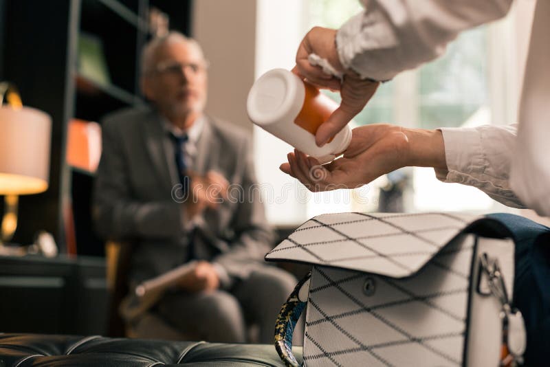 Handen die pillen nemen uit een pillendoos stock afbeeldingen Handen die pillen nemen uit een pillendoos stock afbeeldingen