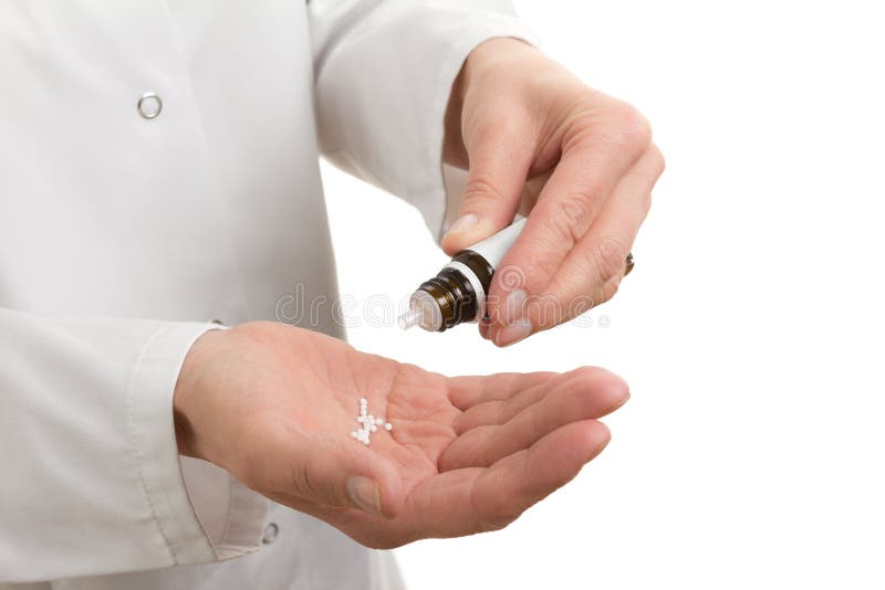 Hands of a traditional healer with homeopathic remedy and bottle, isolated, copy space. Hands of a traditional healer with homeopathic remedy and bottle, isolated, copy space