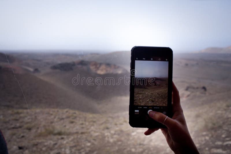 Handen tar bilder, whit somsmartphonen i timanfaya parkerar royaltyfria bilder Handen tar bilder, whit somsmartphonen i timanfaya parkerar royaltyfria bilder