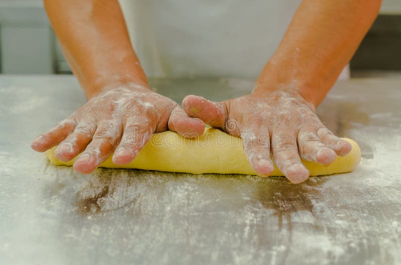 Handen van bakkers werkend, knedend en rollend brooddeeg, die in brood vormen alvorens te koken royalty-vrije stock fotografie Handen van bakkers werkend, knedend en rollend brooddeeg, die in brood vormen alvorens te koken royalty-vrije stock fotografie