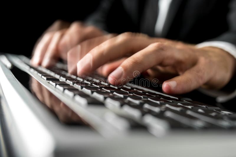 Close-up with motion blur effect of the hands of a man wearing business suit while typing fast on a desktop computer black keyboard. Close-up with motion blur effect of the hands of a man wearing business suit while typing fast on a desktop computer black keyboard.