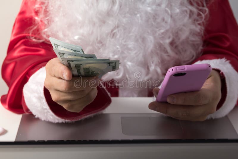 Handen van Santa Claus-holdingsgeld, dollars en smartphone royalty-vrije stock foto's Handen van Santa Claus-holdingsgeld, dollars en smartphone royalty-vrije stock foto's