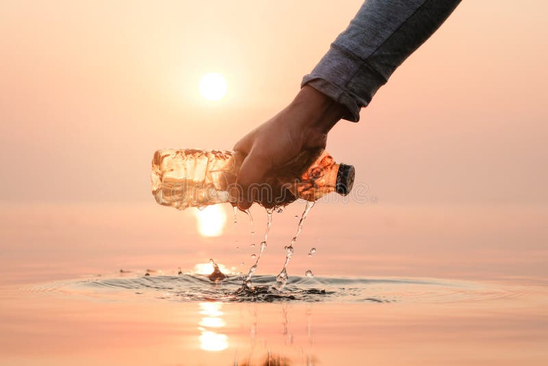 Hand Woman picking up empty of plastic bottle cleaning on the beach , volunteer concept. Environmental pollution. Ecological problem. Hand Woman picking up empty of plastic bottle cleaning on the beach , volunteer concept. Environmental pollution. Ecological problem