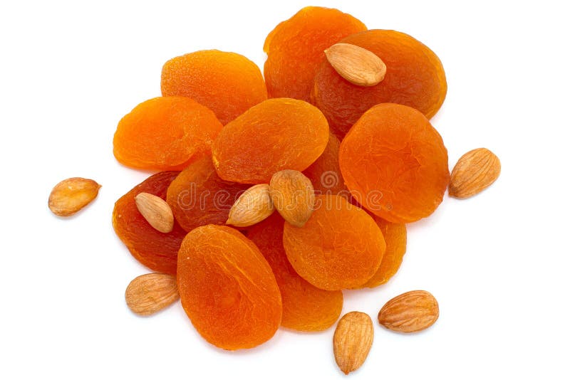 A handful of dried fruit, dried apricots and apricot seeds on a white background