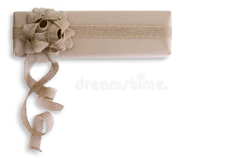 Creative hand crafted Christmas gift with curling burlap bow on a long rectangular brown paper wrapped box isolated on white with copy space. Creative hand crafted Christmas gift with curling burlap bow on a long rectangular brown paper wrapped box isolated on white with copy space