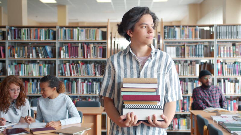 Handha unga studenter som går i akademins bibliotek med böcker i händer stock video