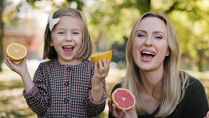 Handhållen vy över mor och dotter som har kul med frukt