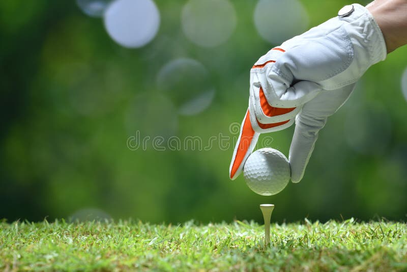Handhållgolfboll med utslagsplatsen royaltyfri fotografi Handhållgolfboll med utslagsplatsen royaltyfri fotografi