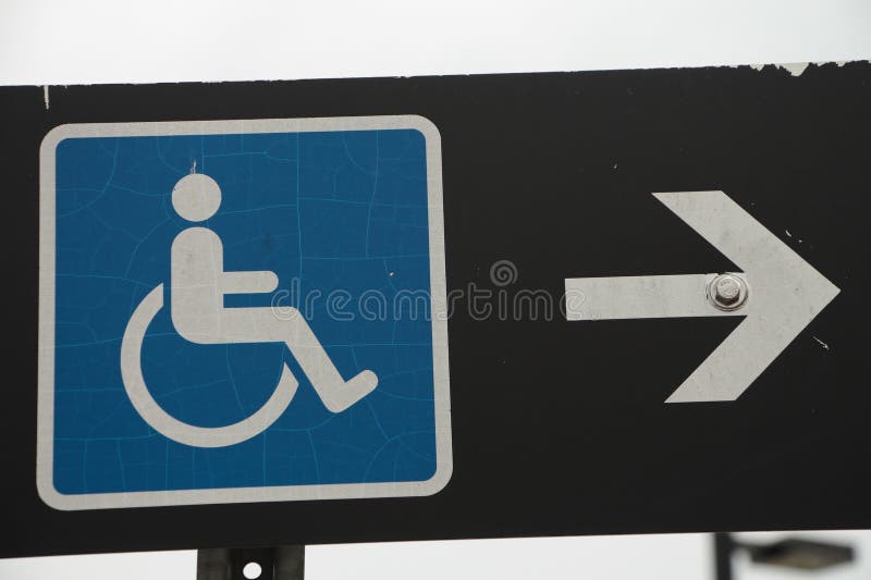 Handicap sign blue logo with white arrow on its right pointing right on black stock images