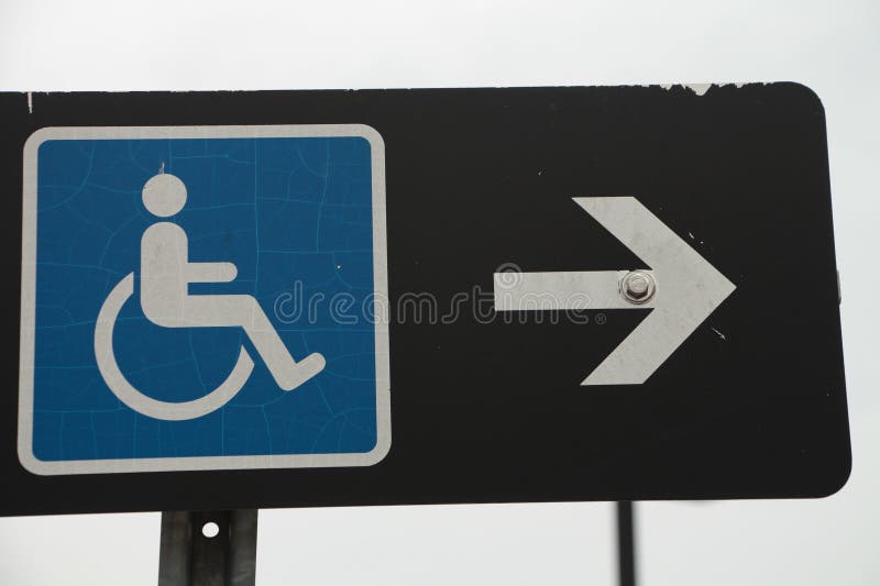 Handicap sign blue logo with white arrow on its right pointing right on black royalty free stock image