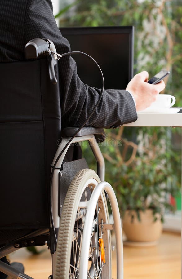 Handicapped businessman texting during work royalty free stock photography