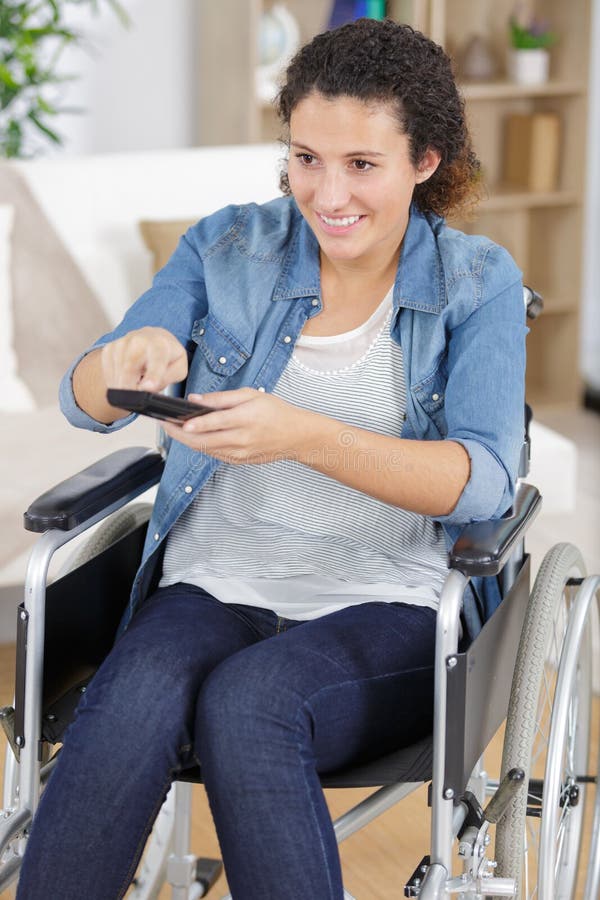 Handicapped woman pressing remote stock photos Handicapped woman pressing remote stock photos
