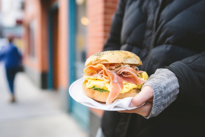 Handing over a breakfast bagel sandwich outside a cafe stock illustration