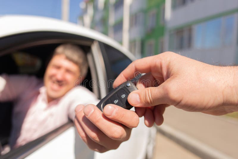 The handing over the key to the new car, the man is happy