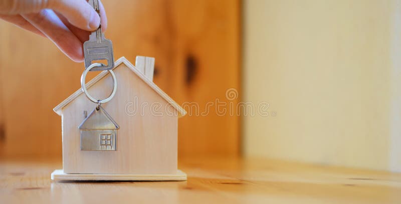 Handinnehav som ger den nyckel- kedjan med den hus formade hängen arkivfoton Handinnehav som ger den nyckel- kedjan med den hus formade hängen arkivfoton