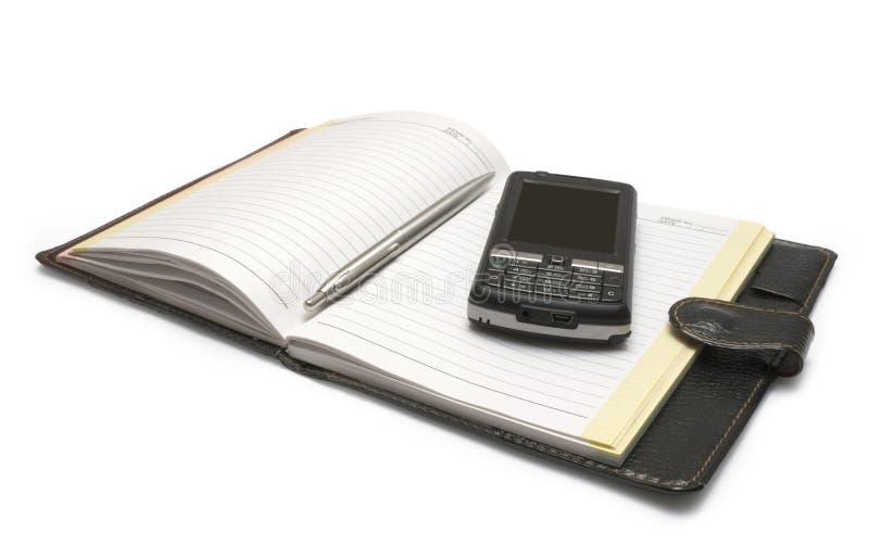 Rukojeť a mobilní telefon ležící na zápisník izolované na bílém pozadí.