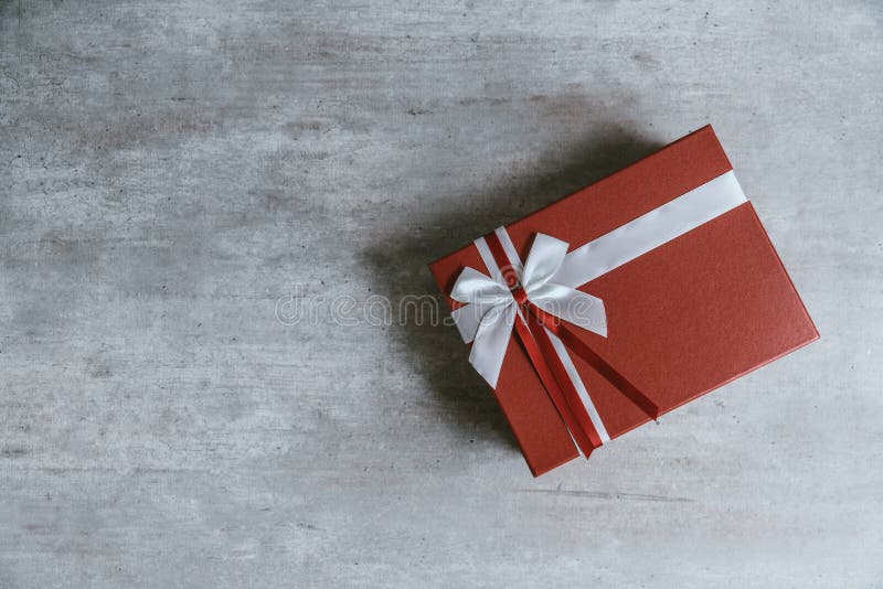 Handmade christmas gift or red present box wrapped in kraft paper with a white ribbon on wooden background. Top view, flat lay, c royalty free stock photography Handmade christmas gift or red present box wrapped in kraft paper with a white ribbon on wooden background. Top view, flat lay, c royalty free stock photography