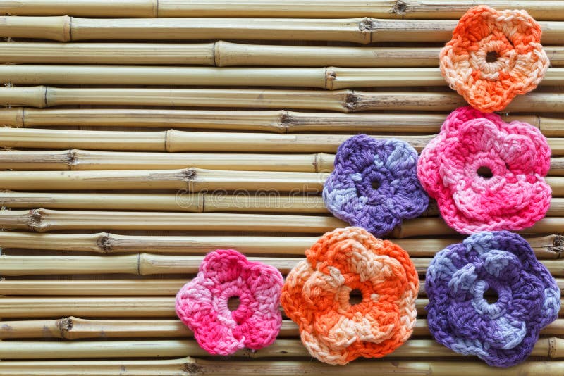 Handmade colorful crochet flowers on bamboo stock photos