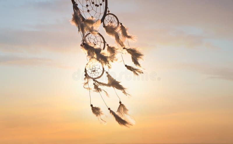 Beautiful handmade dream catcher near river at sunset. Space for text  Photos