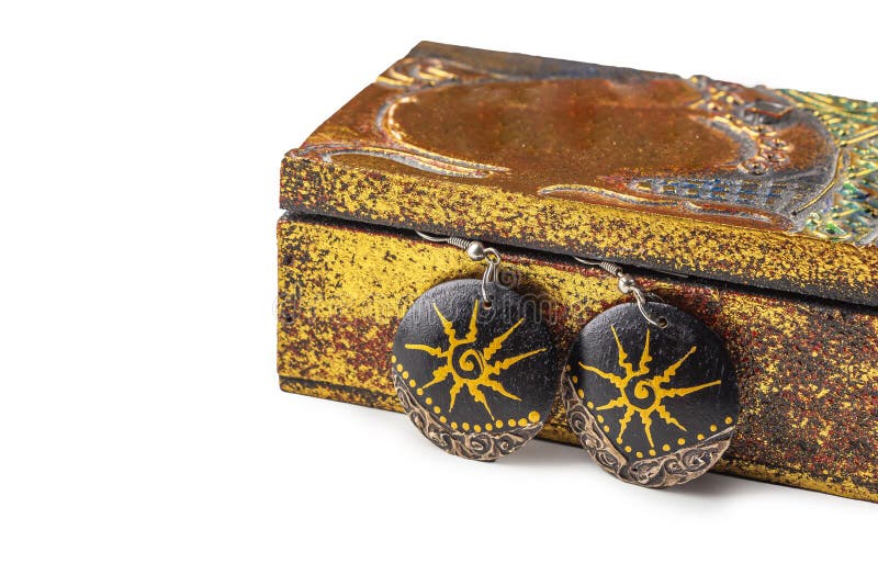 Handmade ethnic wooden earrings of antique metallic vintage casket on white background. Ancient asian-oriental jewelry. Copy space stock photo Handmade ethnic wooden earrings of antique metallic vintage casket on white background. Ancient asian-oriental jewelry. Copy space stock photo