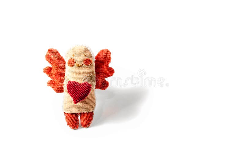 Handmade figurine angel with wings holds in his hands heart made of fabric isolated on white background. Greeting card for