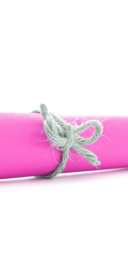Handmade natural cord node tied on pink paper tube isolated stock images Handmade natural cord node tied on pink paper tube isolated stock images