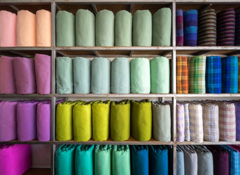 The handmade woven silk rolls in traditional Thai style are on shelves inside a local clothing store in Thailand, front view with the copy space