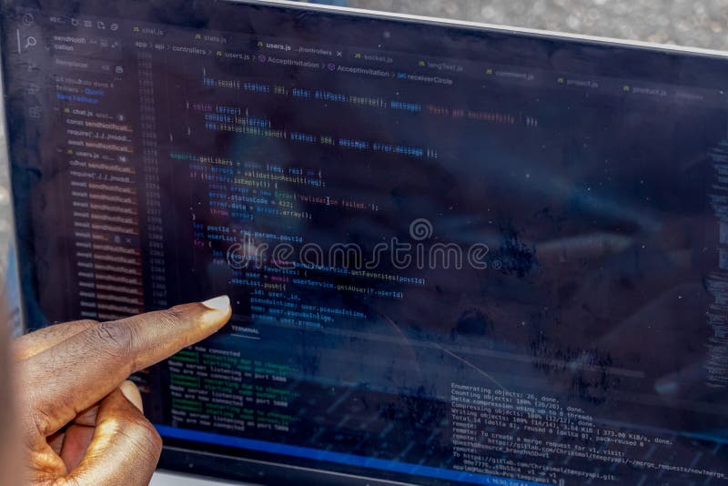 Handportrait afrikanischer Webentwickler, die mit dem Finger auf eine Zeile Computercode zeigen lizenzfreie stockfotos