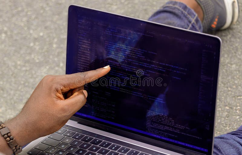 Handportrait afrikanischer Webentwickler, die mit dem Finger auf eine Zeile Computercode zeigen lizenzfreie stockfotos