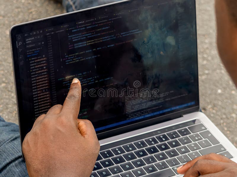 Handportrait afrikanischer Webentwickler, die mit dem Finger auf eine Zeile Computercode zeigen stockfotos