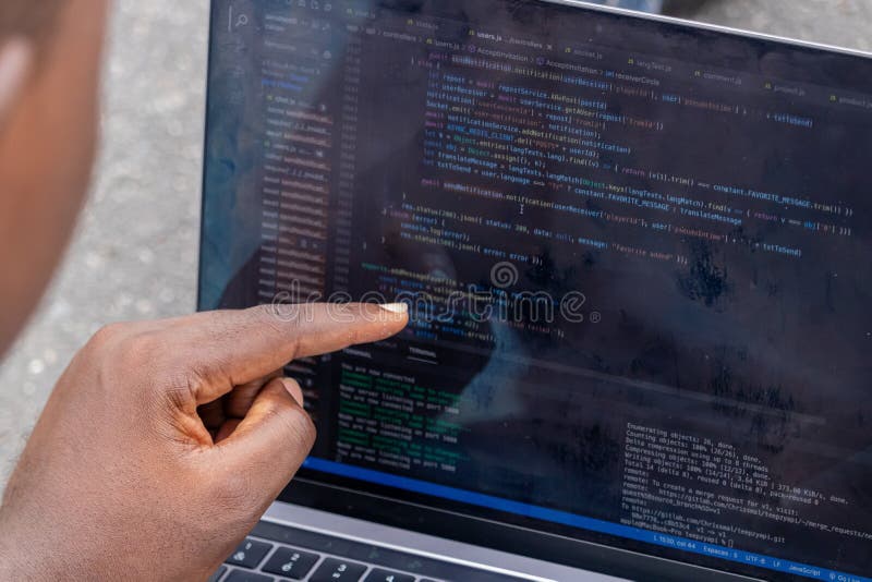 Handportrait afrikanischer Webentwickler, die mit dem Finger auf eine Zeile Computercode zeigen stockfotos