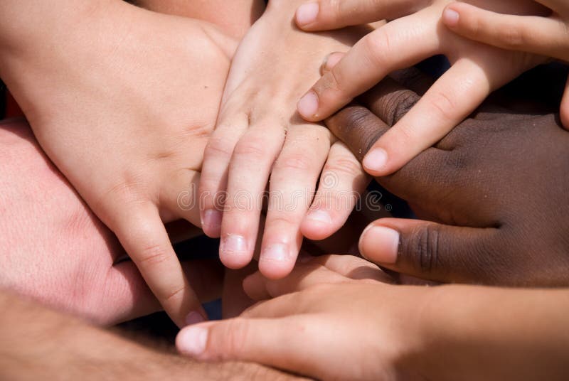 A diverse pile of hands signifying togetherness.