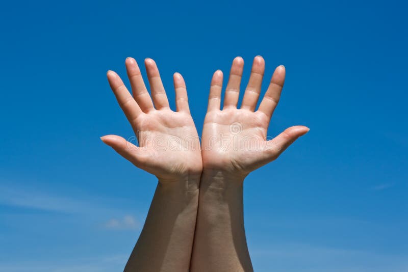 Hands against blue sky stock photography